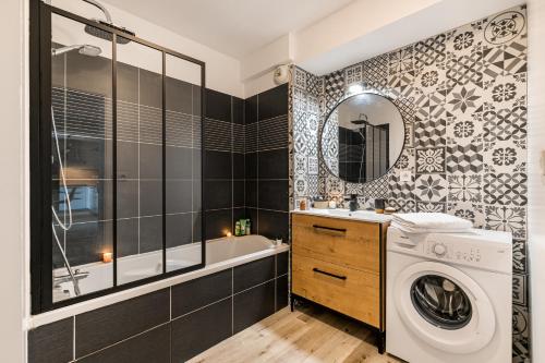 a bathroom with a washing machine and a washer at Le Nouveau Monde - Appartement Chic et Confortable in Saint-Priest
