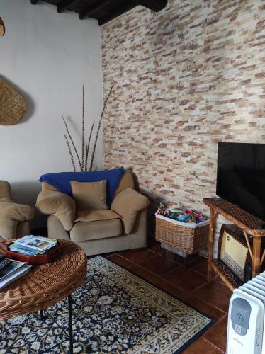 a living room with a couch and a tv at Ribeira da Praia House in Vila Franca do Campo