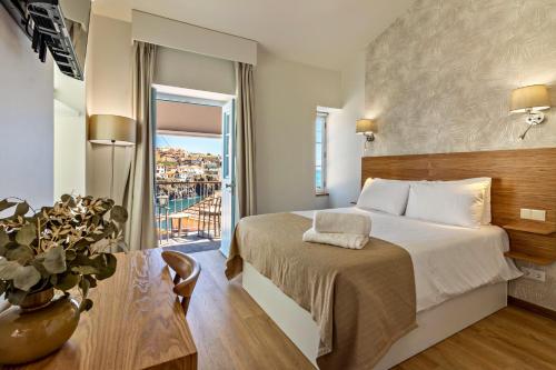 a hotel room with a bed and a balcony at Casa das Andorinhas in Câmara de Lobos