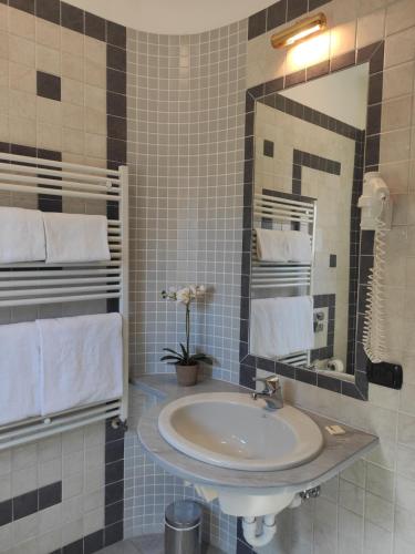ein Bad mit einem Waschbecken und einem Spiegel in der Unterkunft Hotel Giardino in Cannobio