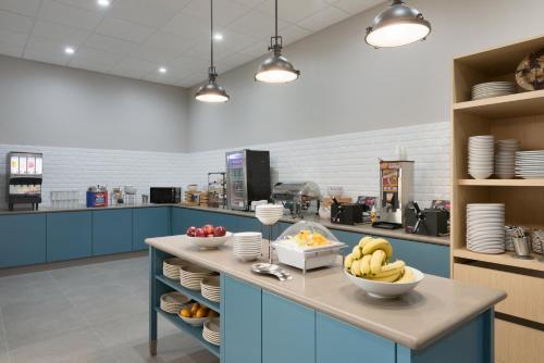 a kitchen with a counter with bowls of fruit on it at Country Inn & Suites by Radisson, Katy Houston West , TX in Katy