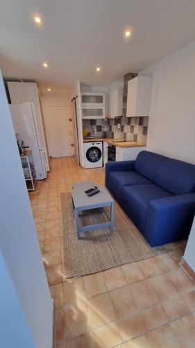 un salon avec un canapé bleu et une table dans l'établissement Studio avec terrasse à Sanary, à Sanary-sur-Mer