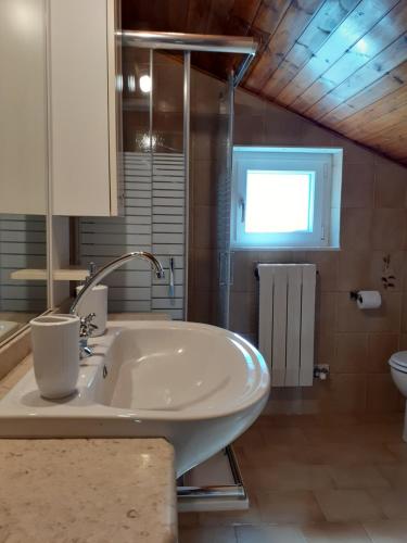 y baño con lavabo blanco y aseo. en Graziosa mansarda rustica - CIR VDA 0038, en Aosta