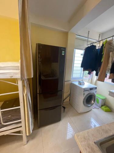 a kitchen with a refrigerator and a washing machine at Bống Homestay in Hai Phong