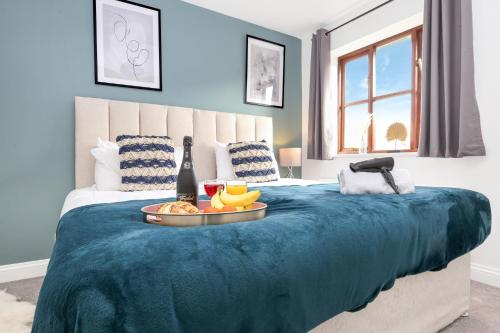 Una cama con una manta azul con una bandeja de comida. en Detached House - Prime Location - Free Parking, Fast Wifi and Smart TVs with Sky TV and Netflix by Yoko Property, en Milton Keynes