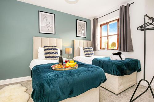 2 camas en una habitación con paredes azules en Detached House - Prime Location - Free Parking, Fast Wifi and Smart TVs with Sky TV and Netflix by Yoko Property, en Milton Keynes