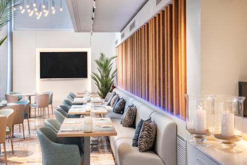 a long row of tables and chairs in a restaurant at Salles Ciutat del Prat Barcelona Airport in El Prat de Llobregat