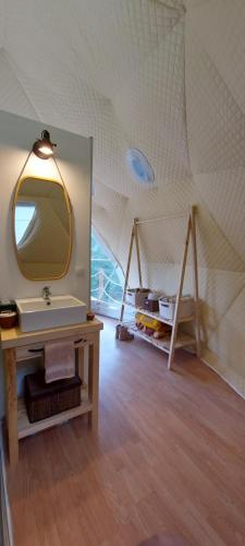 Habitación con baño con espejo y lavabo. en Nomad Glamping, en Šipovo