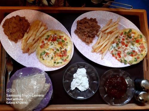 una bandeja con tres platos de comida con patatas fritas y salsas en A&S House en Siwa