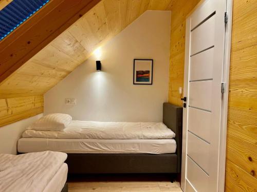 two beds in a small room with a attic at Ptasia Zatoka Sarbinowo in Sarbinowo