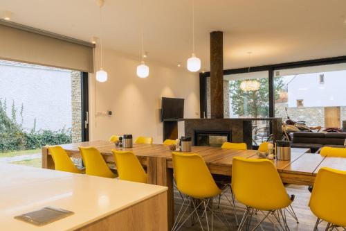 a dining room with a large table and yellow chairs at Penzion Vinařství Konitz in Znojmo