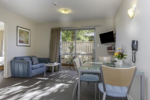 a living room with a table and a couch at 166 Majestic Court Motel in Christchurch