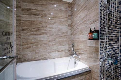 a bathroom with a white bath tub next to a shower at 龍江大飯店 in Shuili