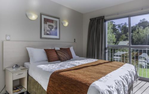 a bedroom with a bed and a balcony at 166 Majestic Court Motel in Christchurch