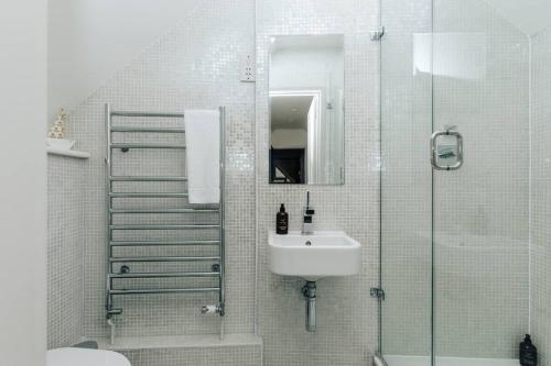 uma casa de banho com um chuveiro, um lavatório e um chuveiro em Hollyhock Lodge em Buckinghamshire