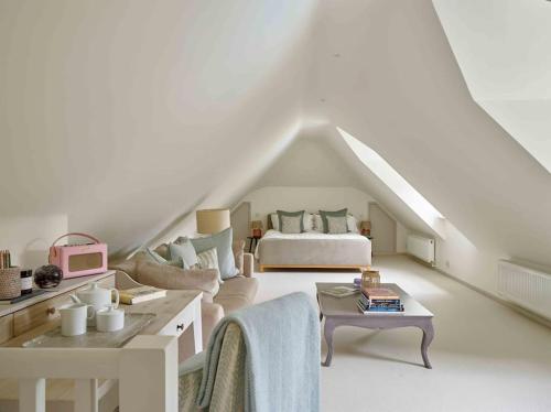 een witte kamer met een bed en een bank bij Hollyhock Lodge in Buckinghamshire