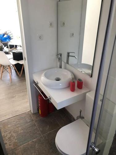 a bathroom with a sink and a mirror and a toilet at La Carihuela Apartamento in Torremolinos