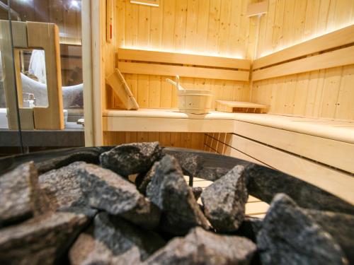 a sauna with a pile of rocks in it at Projekt ŚWIT - domki z prywatną jacuzzi i sauną in Żywiec