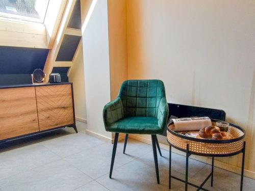 a green chair and a table in a room at Projekt ŚWIT - domki z prywatną jacuzzi i sauną in Żywiec