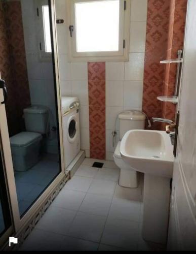 a small bathroom with a toilet and a sink at SKY Management in Hurghada