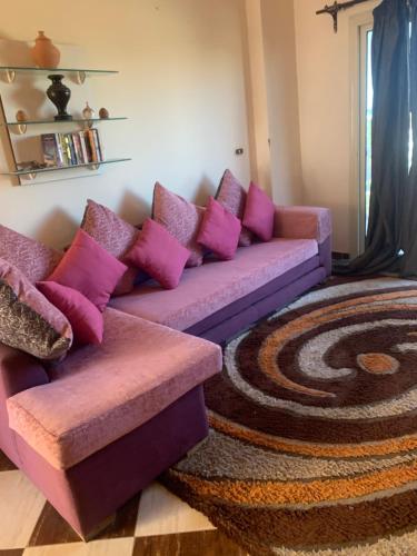 a living room with a purple couch with pink pillows at SKY Management in Hurghada