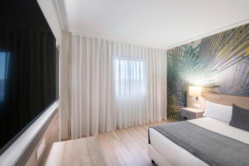 a bedroom with a bed and a large window at Salles Ciutat del Prat Barcelona Airport in El Prat de Llobregat