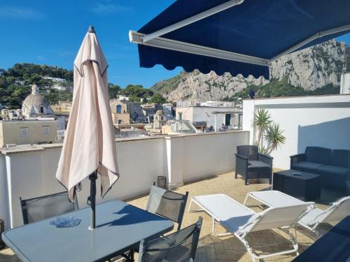 a patio with a table and an umbrella at Romy Blu in Capri