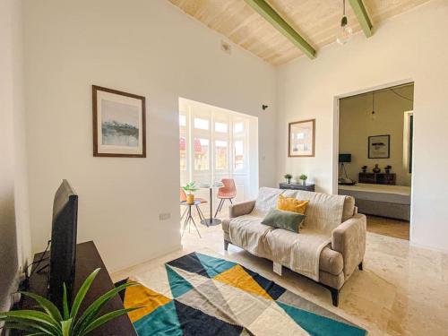 uma sala de estar com um sofá e uma televisão em Designer Furnished - Entire Apartment Sliema 1B by Solea em Sliema