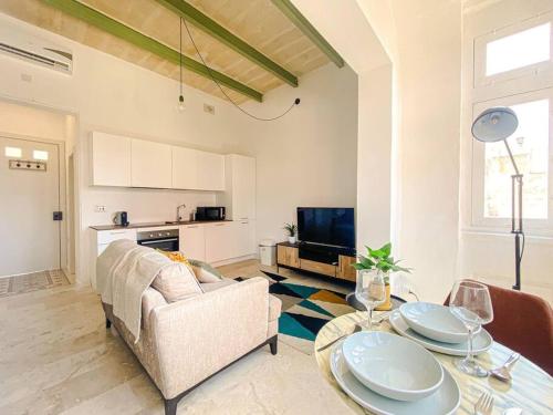 uma sala de estar com um sofá e uma mesa em Designer Furnished - Entire Apartment Sliema 1B by Solea em Sliema