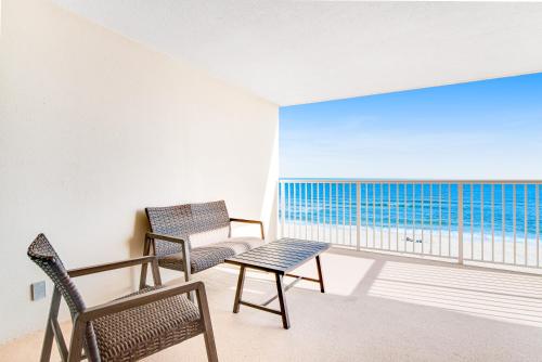 a room with two chairs and a table and a balcony at Sandy Key 3-532 in Perdido Key