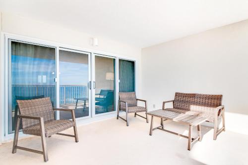 a living room with chairs and a table on a balcony at Sandy Key 3-532 in Perdido Key