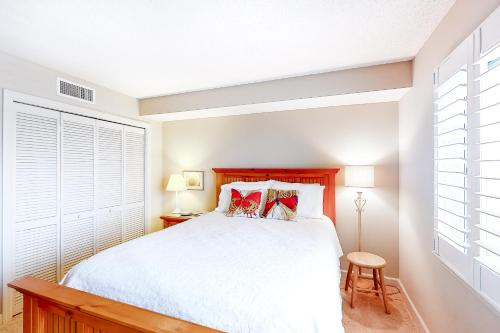 a bedroom with a white bed and a window at Sandy Key 3-532 in Perdido Key