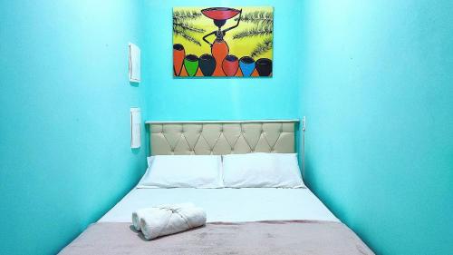 uma cama num quarto azul com um quadro na parede em Studios prox Cataratas e Aduana Argentina em Foz do Iguaçu