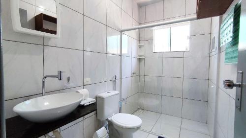 ein weißes Bad mit einem Waschbecken und einem WC in der Unterkunft Studios prox Cataratas e Aduana Argentina in Foz do Iguaçu