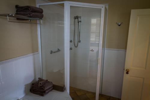 y baño con ducha y puerta de cristal. en Tizzana Winery Bed and Breakfast, en Sackville Reach