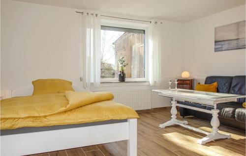 a bedroom with a bed and a table and a window at Gorgeous Apartment In Loxstedt With Kitchen in Loxstedt