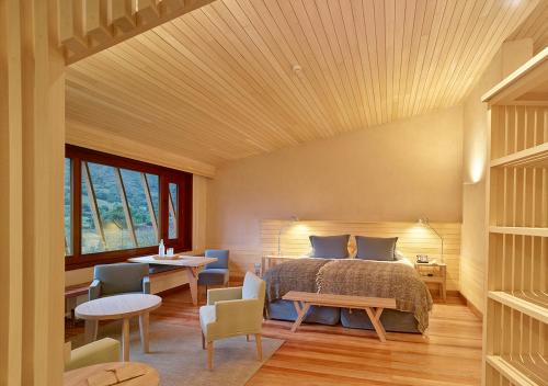 a bedroom with a bed and tables and chairs at Explora Valle Sagrado in Urubamba