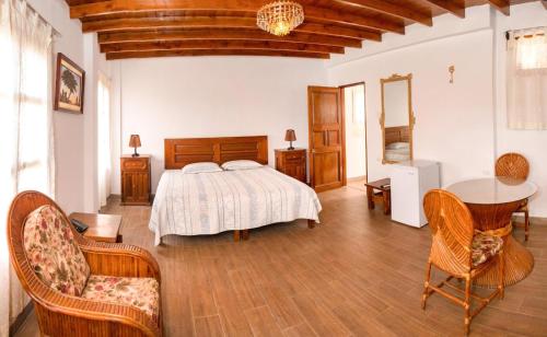 1 dormitorio con 1 cama, mesa y sillas en Bodega el Huarango, en Ica