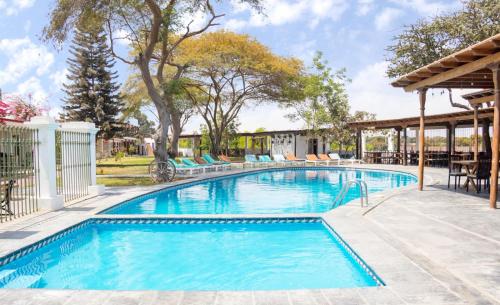 uma piscina com água azul num quintal em Bodega el Huarango em Ica