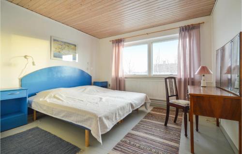 1 dormitorio con cama azul y escritorio en 4 Bedroom Lovely Home In Bandholm, en Bandholm