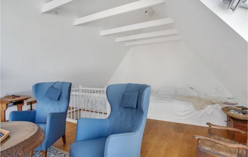 um quarto com duas cadeiras azuis e uma cama em 1 Bedroom Beautiful Apartment In Sejer em Sejerby