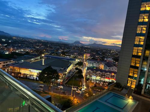 a view of a city at night from a building at Imperial Grand Suite Apartment Kuching in Kuching