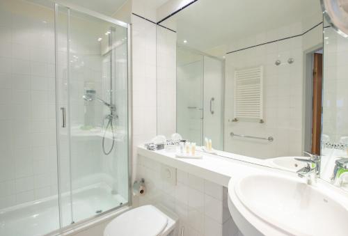 a bathroom with a shower and a sink and a toilet at Inselhotel Poel in Gollwitz