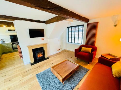 a living room with a couch and a fireplace at Abbey Gardens Cottage in Bury Saint Edmunds