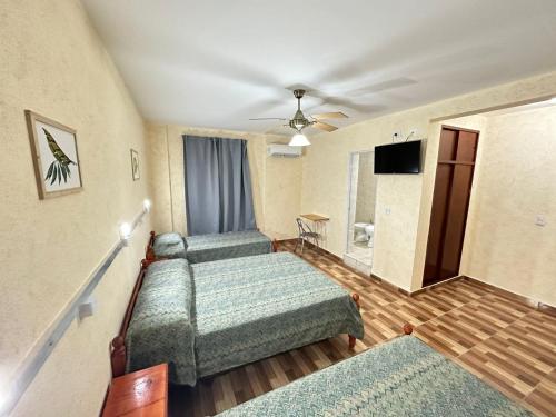 um quarto com 3 camas e uma televisão de ecrã plano em Centro1555 em Buenos Aires
