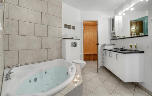 a white bathroom with a tub and a toilet at Lovely Home In Bogense With Kitchen in Bogense