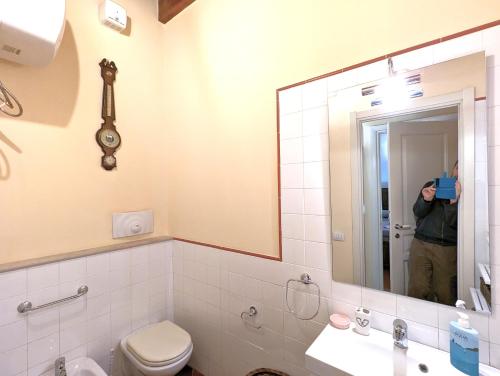 a man taking a picture of a bathroom mirror at La Casa Delle Fate in Siracusa