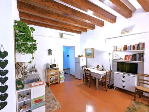 a kitchen and dining room with white walls and wooden ceilings at La Casa Delle Fate in Siracusa