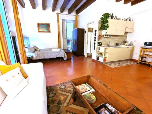 a living room with a table and a kitchen at La Casa Delle Fate in Siracusa