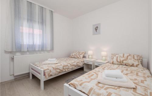 a white room with two beds and a window at Cozy Home In Debelo Brdo I With Wifi in Debelo Brdo